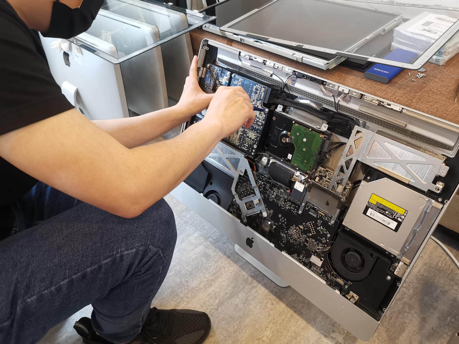 apple technician on dissambling imac motherboard for repair