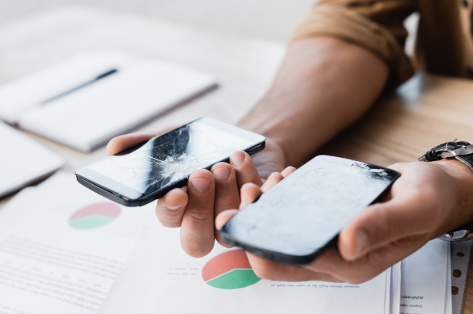 a man holding broken iphones on both hands